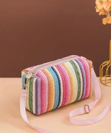 Colorful rainbow pattern woven straw crossbody bag.