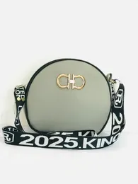 gray round crossbody bag with a wide black and white