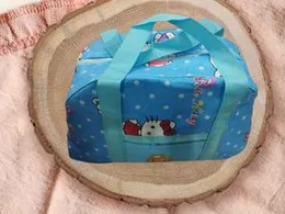 Â Blue, water-resistant baby diaper bag with an animal and flower pattern.Â 