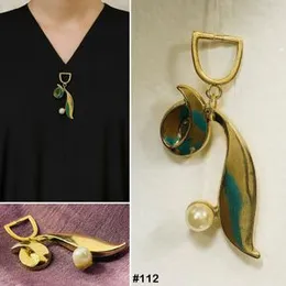 Gold-tone brooch with a faux pearl and turquoise enamel accents.