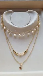 Multi-layered necklace featuring gold-toned chains and freshwater pearls